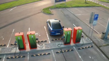 PRAG, CZECH REPUBLIC - 10 Eylül 2024: Modern şehirdeki kamu şarj istasyonuna bağlı elektrikli otomobil. Alternatif enerjiyle Skoda Enyaq çevre kirliliğini azaltıyor