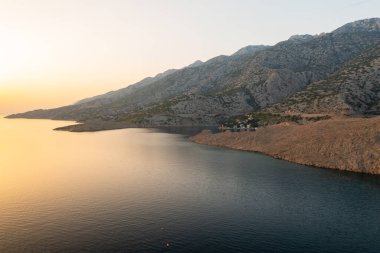 Etrafı denizle çevrili engebeli dağların arasındaki sahil köyü. Kırmızı kiremitli çatıları ve yemyeşil bahçeleri olan küçük evler güzel manzaralar yaratıyor.