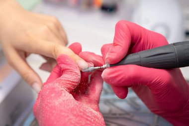 Bir kuaförde manikür için tırnak matkabı kullanan yetenekli bir teknisyen.. 