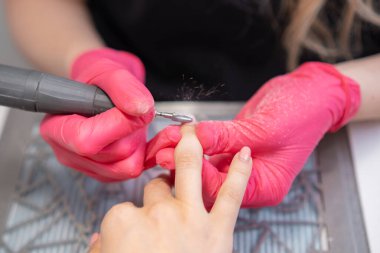 Manikür yapan tırnak teknisyeni güzellik salonundaki müşterilerin parmaklarını tırnak matkabıyla deldi.