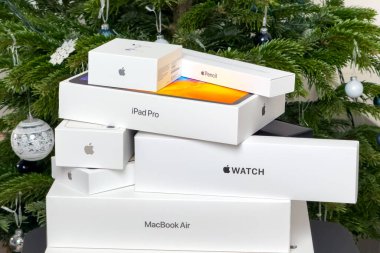 BERLİN, GERMANY - 14 HAZİRAN 2024: Hava kapsüllü kutular, Apple saat, Macbook Pro, Macbook Air, iPad pro ve iPhone Noel ağacı altında.