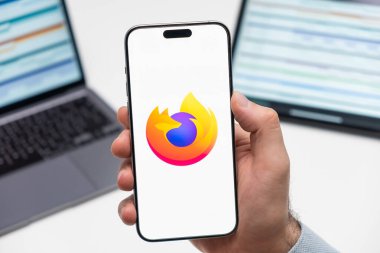 PRAG, CZECH REPUBLIC - 21 Ocak 2024: Mozilla Firefox logosu, erkek elinin akıllı telefon ekranında işyeri arka planında. 
