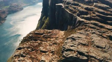 Iconic Preikestolen, Lysefjord 'un durgun sularıyla çarpışıyor. Uçsuz bucaksız kaya oluşumu ve Norveç hava manzarası manzarası.