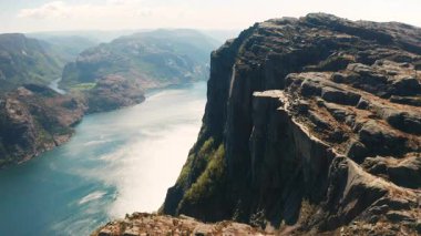 Önceki bölümlerde Lysefjord 'un engin genişliğine tepeden bakan keskin uçurumlar görüldü. Norveç arazisinin yabani güzelliği ve ışıldayan fiyort suları