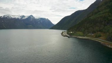 Hardanger fiyortta sarp yeşil dağlarla çevrili geniş sakin sular bulunur. Norveç 'in kıyı şeridi boyunca yol ve binaları olan küçük bir yerleşim yeri