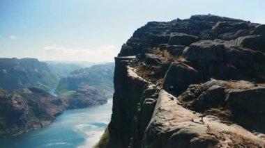 Lysefjord 'a bakan dramatik uçurum yüzüyle Preikestolen' in nefes kesici manzarası. Norveç 'teki fiyort sularının ve doğal simgelerin görkemli ölçeği