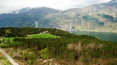 Majestic Hardanger Köprüsü geniş bir su kütlesini geniş tepeler ve dağlar arasına kurar. Askıya alınan köprü zarif kuleler manzarada göze çarpıyor