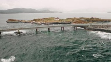 Arabalar Atlantik Okyanusu yolunda büyük adaları birbirine bağlayan köprüyle yol alırlar. Küçük ev, Norveç 'in dramatik kıyı sahnesine insan varlığı katıyor