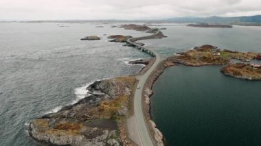 Atlantik Okyanusu yolu zarif kıvrımlar ve sayısız küçük adacıkları vurgular. Hassas yollar, bulutlu gökyüzünün altındaki arazileri birbirine bağlayan sularda zikzak çizer.