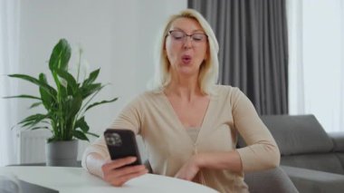 Mutlu kadın cep telefonuna bakar ve 