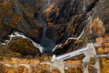 Görkemli Voringsfossen şelalesi engebeli vadi içinde güçlü çağlayanlarla havuza yaklaşıyor. Norveç 'te doğal güzelliğin ham gücü ve güzelliği