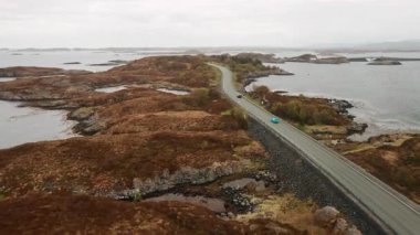 Atlantik Okyanusu yolu, kayalık adalarda dolanan dar bir patikayı gözler önüne seriyor. Denizler arasında çarpıcı bir bağ oluşturuyor. Norveç 'in bulutlu gökyüzü altındaki manzarası