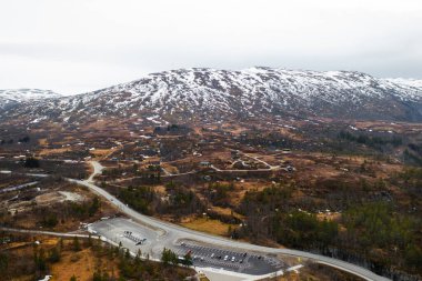 Muhteşem Voringsfossen şelalesi kayalık kayalıklarla çevrili engebeli kanyona daldı. Dolambaçlı yol ve seyrek bitki örtüsü