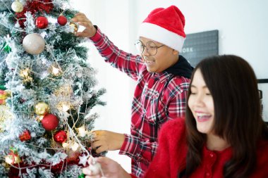 Mutlu Asyalılar Noel ağacını fantezi Noel balolarıyla süslemeyi ve birlikte hediyeler vermeyi severler. Mutlu insanlar yeni yıl ve Noel partisi için evlerini ya da evlerini hazırlıyorlar..