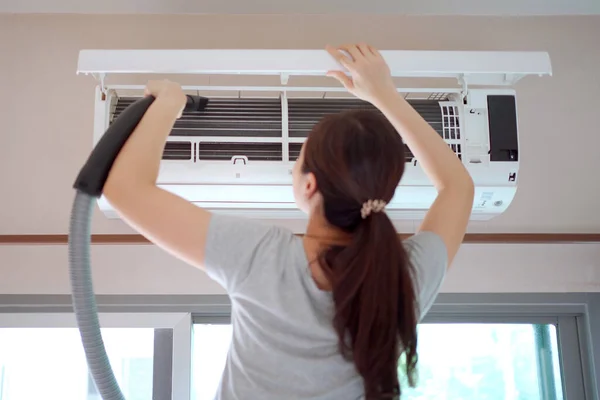 Asiatisk Kvinnlig Hushållerska Klättrar Stege För Att Rengöra Ett Luftkonditioneringsfilter — Stockfoto