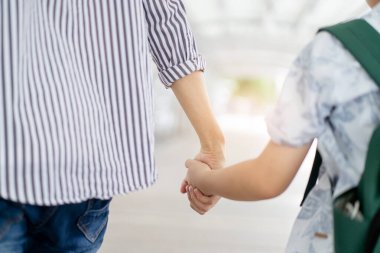 Baba oğlunu okula götürüyor, okula yürürken çocuk elini tutan bir adam..