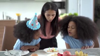 Mutlu bir aile birlikte doğum günü kutlaması, anne ve kızı küçük bir doğum günü pastasıyla kızına sürpriz yapıyor..
