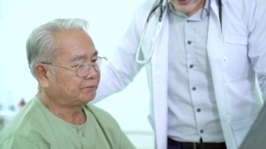 Asian elder adult having a consult with doctor about his disease, doctor explains the x-ray film to Asian senior adult. Health care and wellness in aging society.