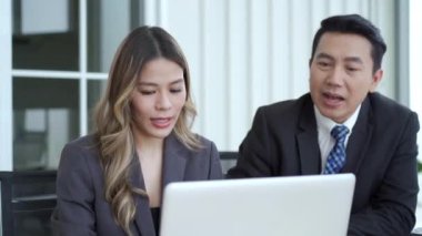 Asyalı işadamı ve iş kadını ofiste birlikte konuşuyor, bir işadamı, kadın sekreteriyle dizüstü bilgisayardaki iş projesi hakkında konuşuyor ya da tartışıyor - bilgisayar ekranı.