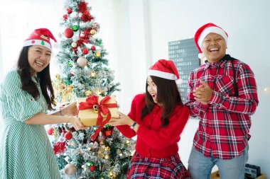 Mutlu Asyalılar Noel ağacını fantezi Noel balolarıyla süslemeyi ve birlikte hediyeler vermeyi severler. Mutlu insanlar yeni yıl ve Noel partisi için evlerini ya da evlerini hazırlıyorlar..