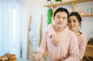 Mutlu genç çift mutfakta birlikte kahvaltı hazırlıyor. Romantik Asyalı genç çift sabahları kahvaltı hazırlıyor..