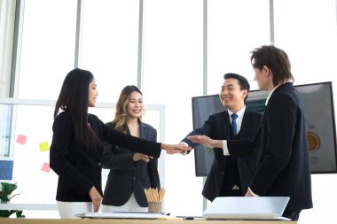 Asyalı kıdemli işadamı yıllık veya mali yıl iş planı toplantısını birlikte sunuyor. Neşeli yönetici işadamları ve iş kadınları takım çalışması konseptini göstermek için el ele tutuşuyorlar..