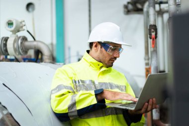 Otomatik üretim fabrikasındaki makineleri inceleyen Asyalı profesyonel makine mühendisi. Uzman mesleği kavramı.