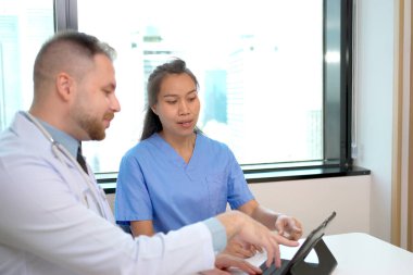 Uzman doktorlar hastane oturma odasında ya da dinlenme alanında tıbbi planlama hakkında tartışıyorlar..