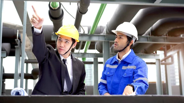 Professional Asian foreman and construction manager talking - discussing about building structure plant together. Businessman and construction engineer having a discussion.