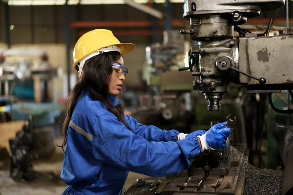 Female mechanical engineer working in the factory, engineer inspecting and fixing a metal machine system the factory. Female mechanical technician fixing a machines.
