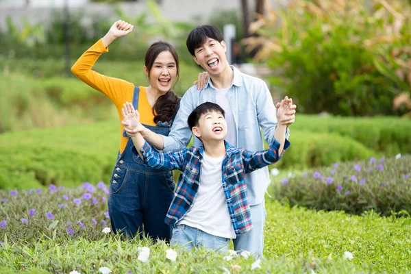 stock image Happy Asian family father mother and son posing for a photography in flowers and botanical garden. Portrait of cheerful Asian family doing a weekend activity together in flower - botanical garden.