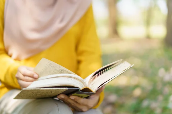 幸せな陽気なアジアの美しいイスラム教徒の女性の本を読んで コーランの木の下に イスラームを学ぶムスリム女子学生コーラン — ストック写真