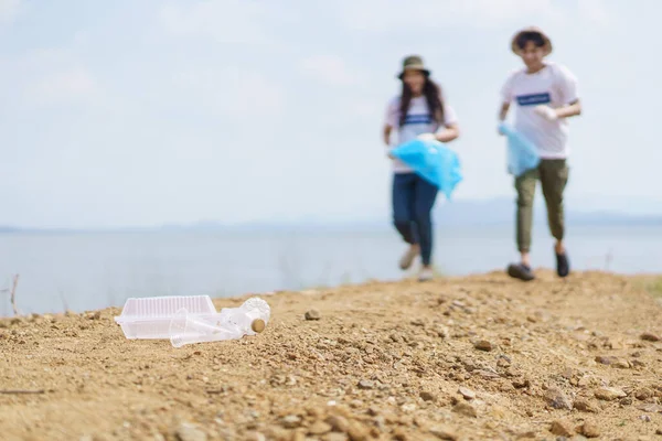 一群亚洲年轻人志愿帮助在公园的地上收集或捡拾塑料瓶垃圾 可持续发展和环境保护概念 — 图库照片