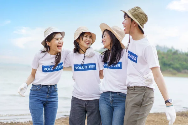 stock image Group of Asian young people volunteer helping to collecting or picking up a plastic bottle garbage on the ground in park. Sustainability and environment conservation concept.