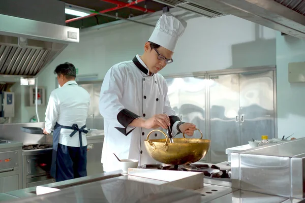 在亚洲餐厅的厨房里 快乐的亚洲专业厨师在做饭 中国厨房里的男性专业厨师 — 图库照片