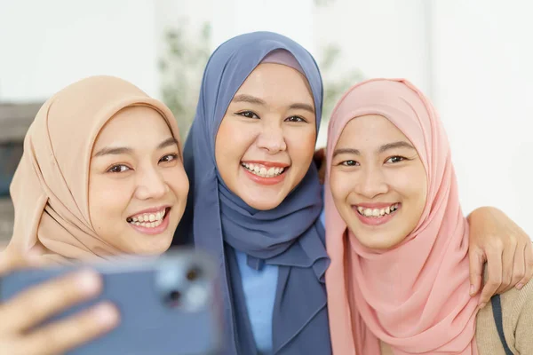 幸せな陽気なアジアのイスラム教徒の女性のグループは スマートフォンを使用して写真を撮るか ソーシャルネットワーク上でライブストリーミングビデオを作る — ストック写真