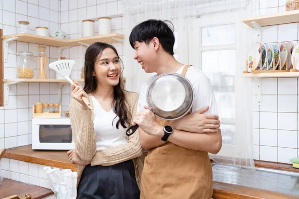 stock image Happy cheerful Asian young couple portrait in kitchen together.