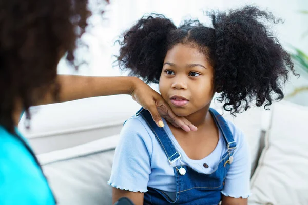 stock image African American ethnicity female doctor and little girl in hospital, pediatrician taking to a little girl who laying down on the bed or sofa in hospital to talk about her sickness.