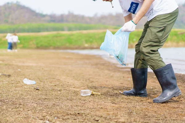 亚洲年轻人在海滩捡塑料瓶垃圾 男性志愿者在海滩上散步 收集和清理塑料垃圾 — 图库照片