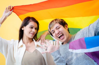 Mutlu Asyalı adam ve beyaz kadın portresi LGBTQ + 'da gökkuşağı bayrağı konseptiyle.