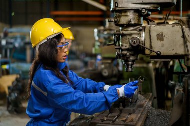 Fabrikada çalışan kadın makine mühendisi, fabrikanın metal makine sistemini inceleyip tamir eden mühendis. Makineleri tamir eden kadın mekanik teknisyen..