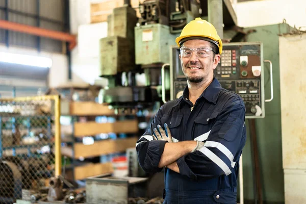 stock image Professional caucasian white ethnicity male technician operating the heavy duty machine in the lathing factory. Technician in safety and helmet suit controlling a machine in factory.