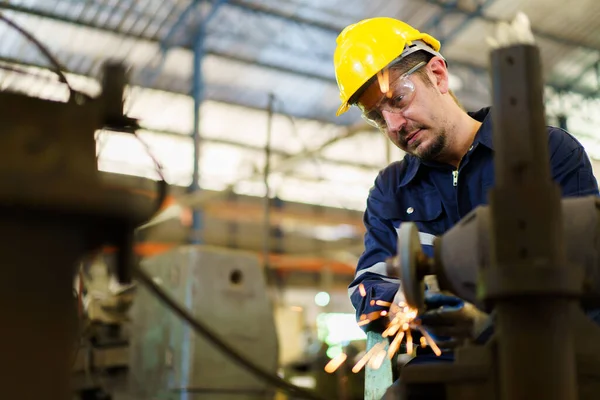 stock image Heavy industry metal work worker using metal grinder machine sharpening a metal pipe close up.