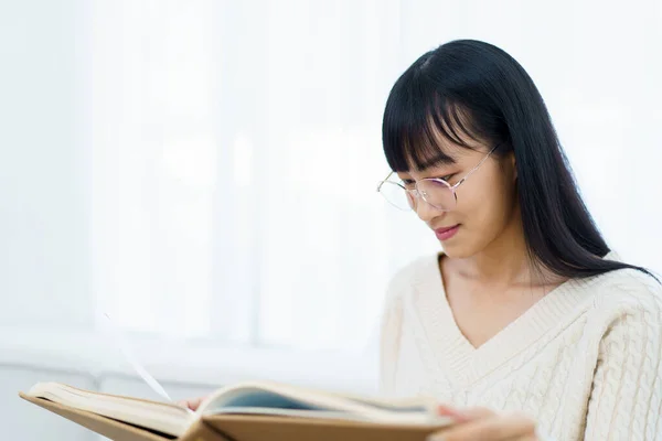 Boldog Vidám Ázsiai Fiatal Szemüveg Kanapén Nappaliban Olvasás Egy Könyvet — Stock Fotó