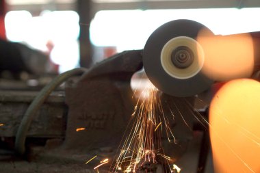 Metal öğütücü makinesiyle metal boru keskinleştiren ağır endüstriyel metal işçisi..