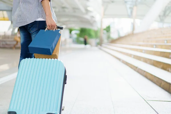 アジアの若者は ショッピングバッグで街や空港ターミナルにスーツケースをドラッグします 都市や都市部を旅行する男 — ストック写真