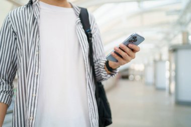 Mutlu Asyalı erkek gezgin şehirde kayboldu ve haritayı görmek için akıllı telefon kullandı..