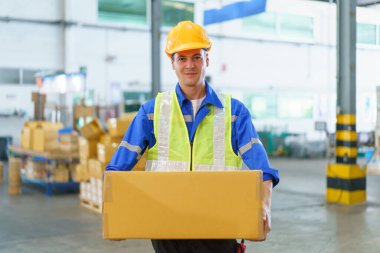 Fabrikada ya da depoda çalışan Kafkas asıllı profesyonel beyaz erkek depo çalışanı. Beyaz erkek depo çalışanı toplanıyor ve paket paketi gösteriyor..