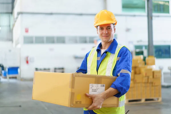 Professional caucasian white male warehouse worker working in the factory or warehouse, caucasian male warehouse employee packing and showing parcel package.