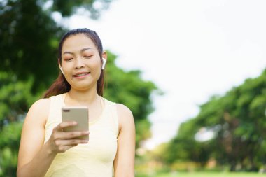 Güzel, zeki ve yakışıklı Asyalı yetişkin bir kadın güzel bir günde yoga ya da vücut ağırlığı egzersizi yapıyor ve çim tarlasında yoga yapıyor. Refah ve sağlıklı yaşam tarzı kavramı..